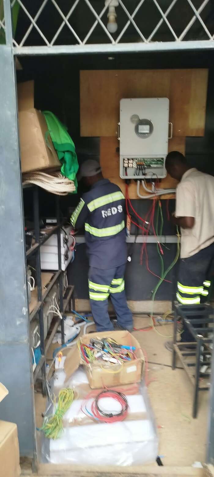 REDS technicians installing a solar inverter